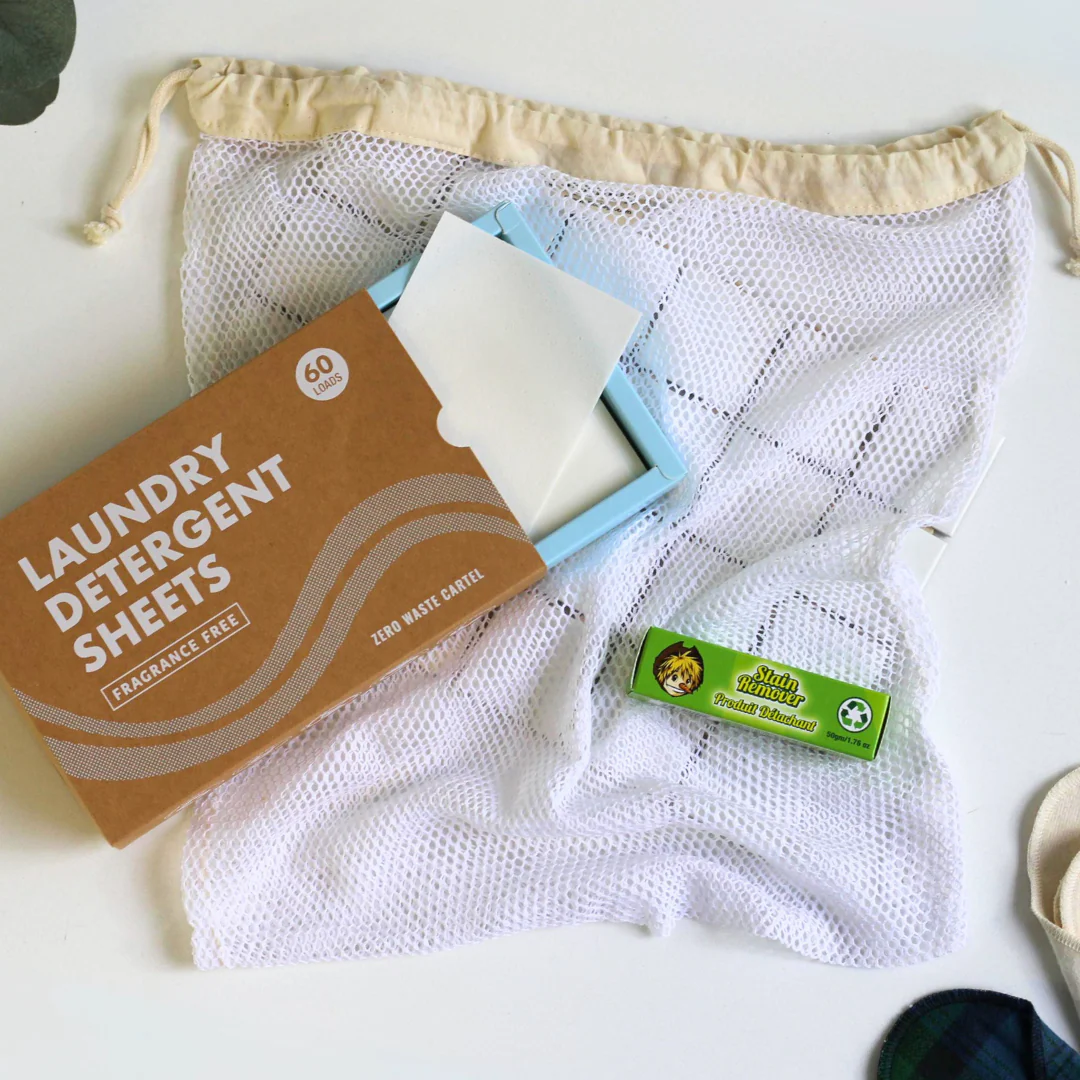 Mesh laundry bag placed under box of laundry detergent sheets and buncha farmers stain remover stick 
